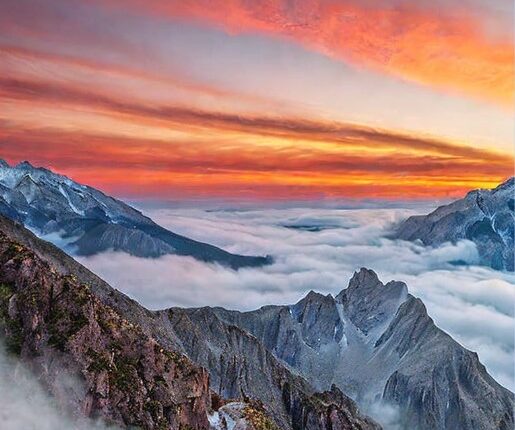 Lonely peak, peeks above clouds, sunrise paints it golden pink. Misty valleys below, waterfall sings, magic feels close. Picture-perfect view, soft colors, like a dreamy painting.